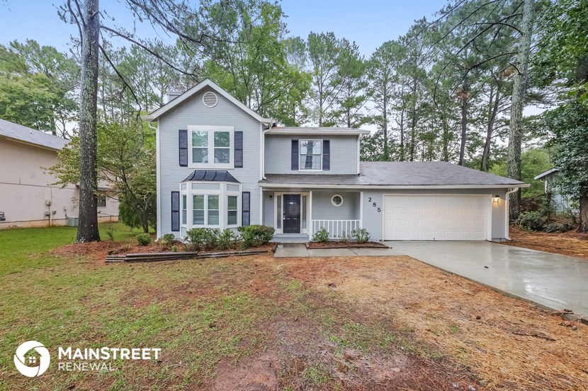 a white house with a yard and trees