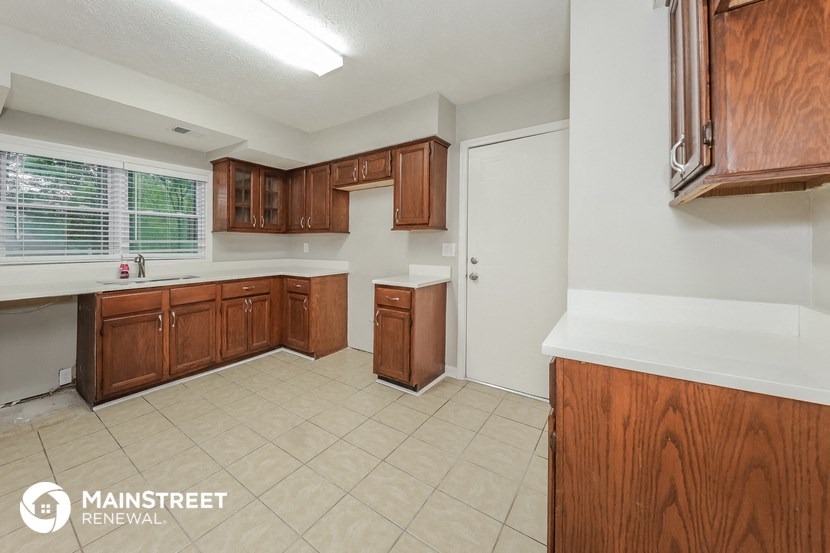 a kitchen with wooden cabinets and a white tile floor