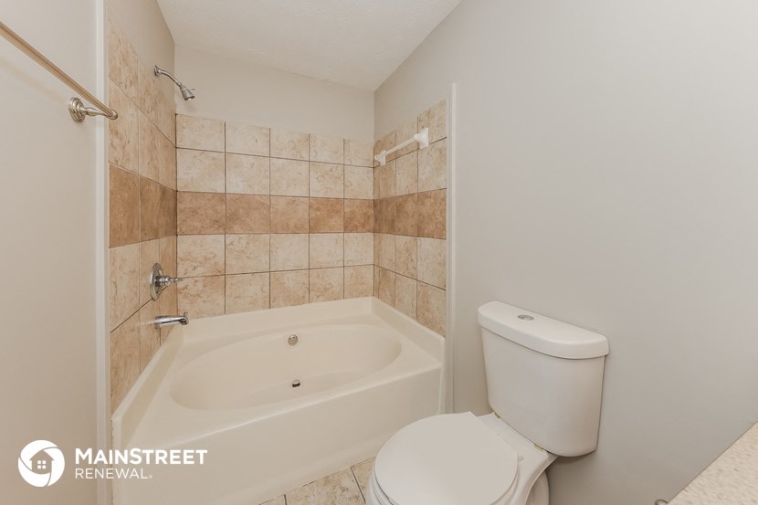 a bathroom with a toilet and a bath tub