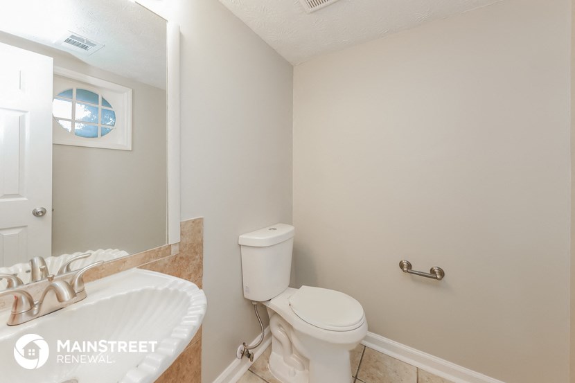 a bathroom with a toilet and a sink and a mirror