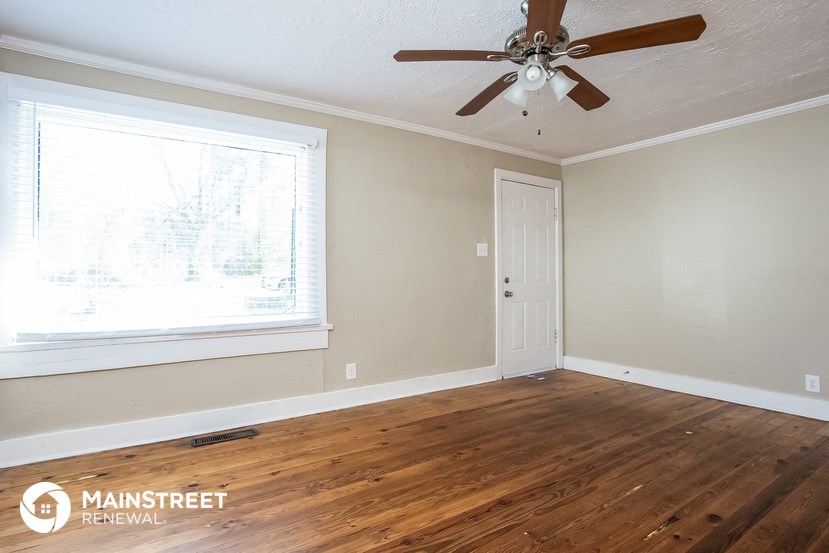 the master bedroom has a large window and a ceiling fan