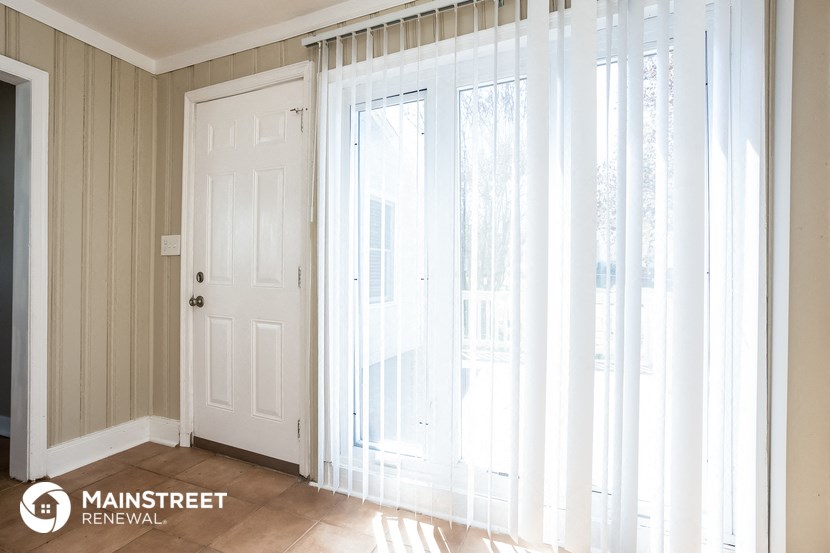 a living room with large windows and a white door