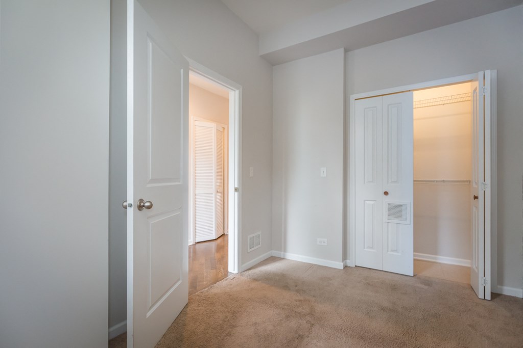 an empty bedroom with a closet and a door to a closet