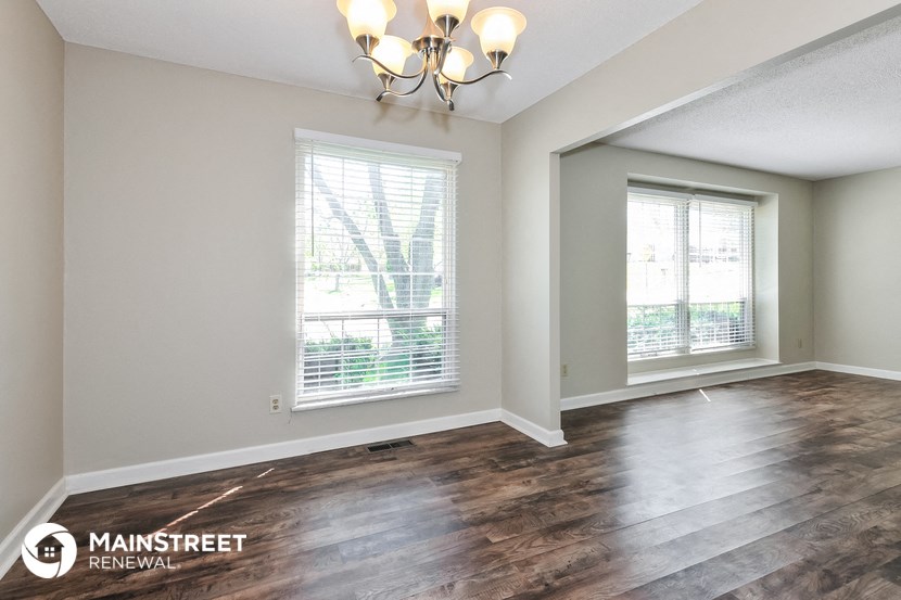 the living room of a new home with wood flooring and a large window