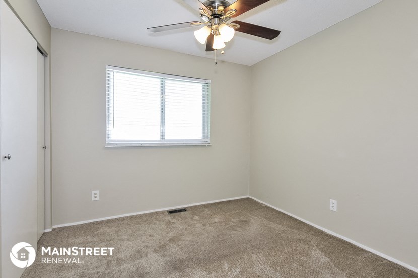 a bedroom with a ceiling fan and a window