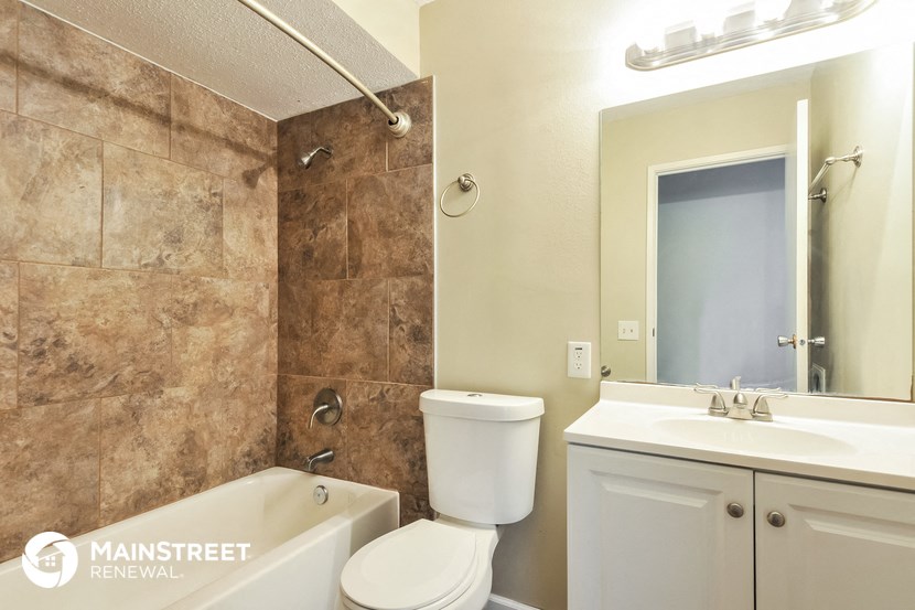 a bathroom with a toilet sink and tub and a mirror