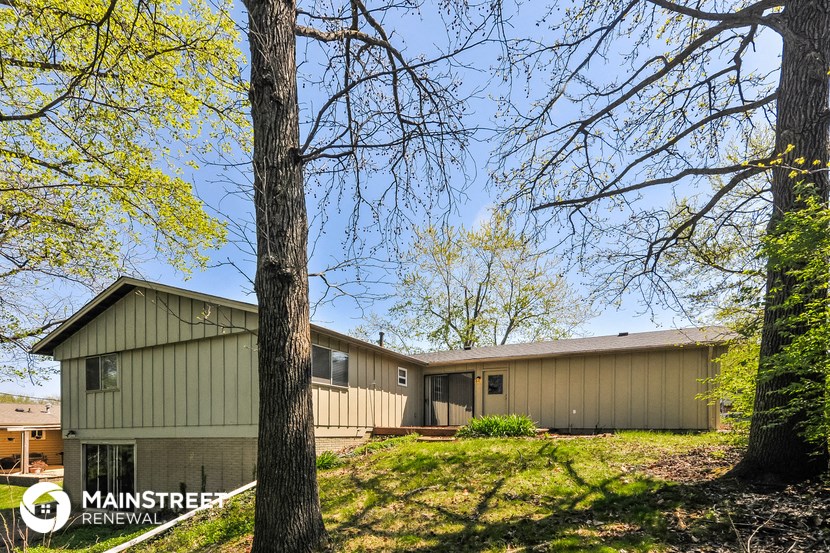 a green house with trees in front of it