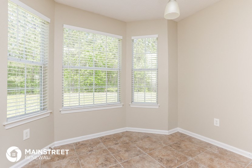 an empty room with three windows and a tiled floor