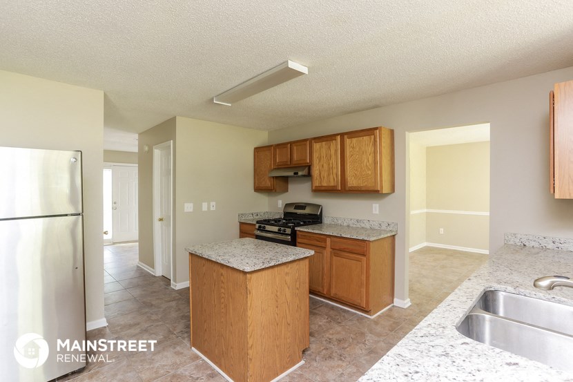 a kitchen with wood cabinets and granite counter tops and a stainless steel refrigerator