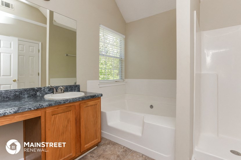 a bathroom with a tub and a sink and a mirror