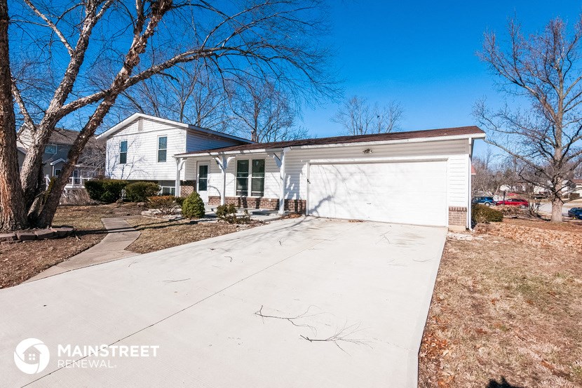 a white house with a driveway and a white garage door