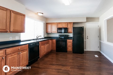 a kitchen with wooden cabinets and black appliances