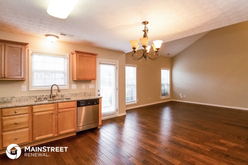 the kitchen and living room of an empty house with wood flooring