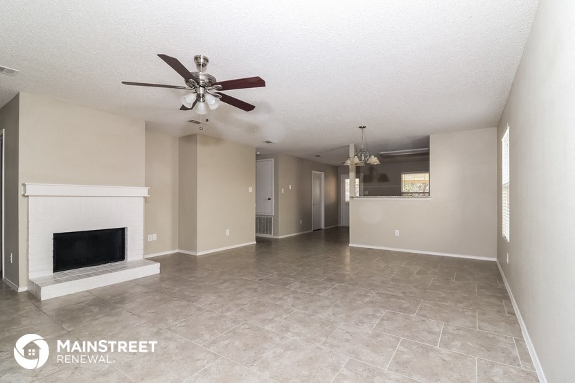 a living room with a fireplace and a ceiling fan