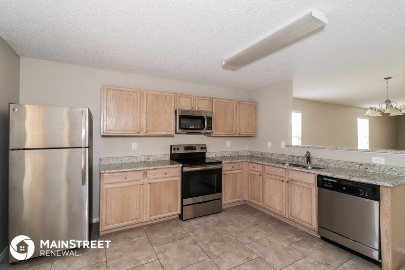 a kitchen with wooden cabinets and stainless steel appliances