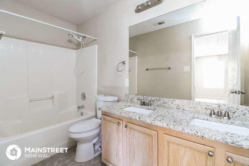 a bathroom with a shower toilet and sink and a mirror