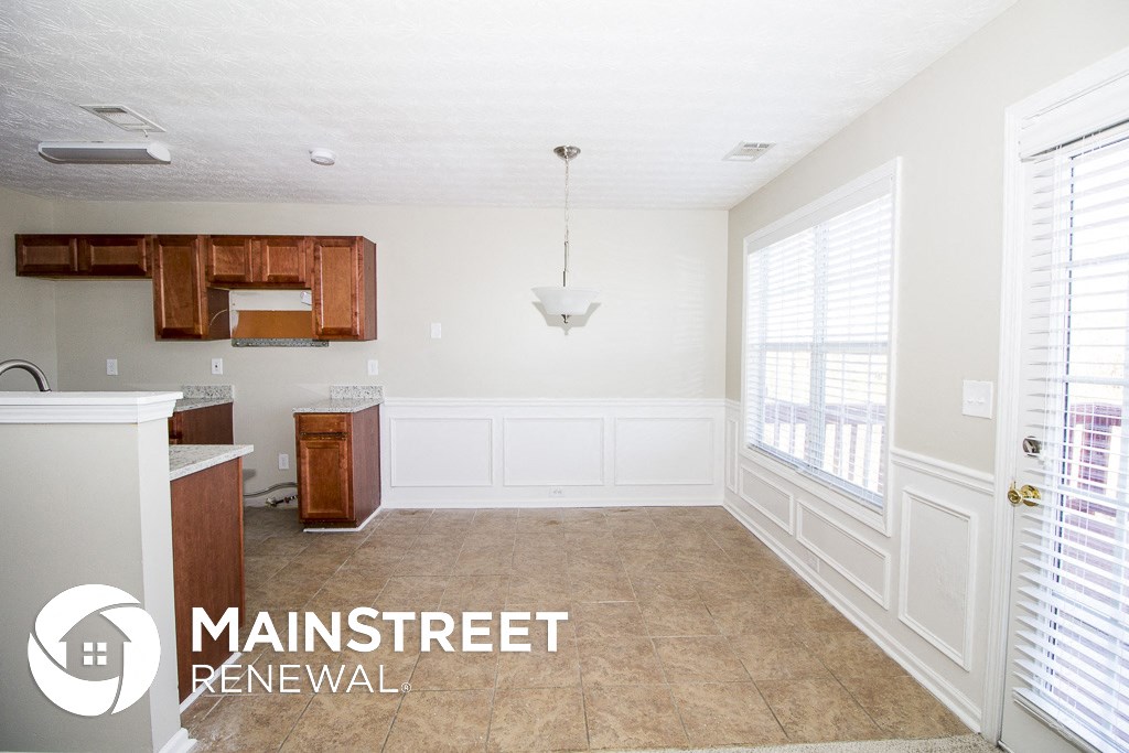an empty kitchen with white walls and tile flooring