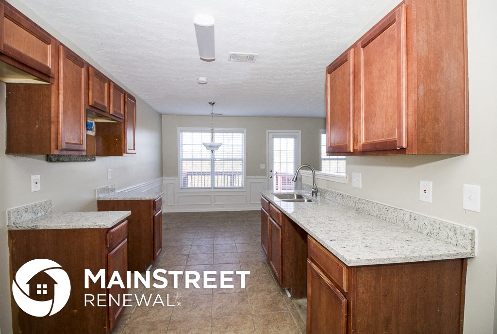 a kitchen with wood cabinets and marble counter tops and a sink