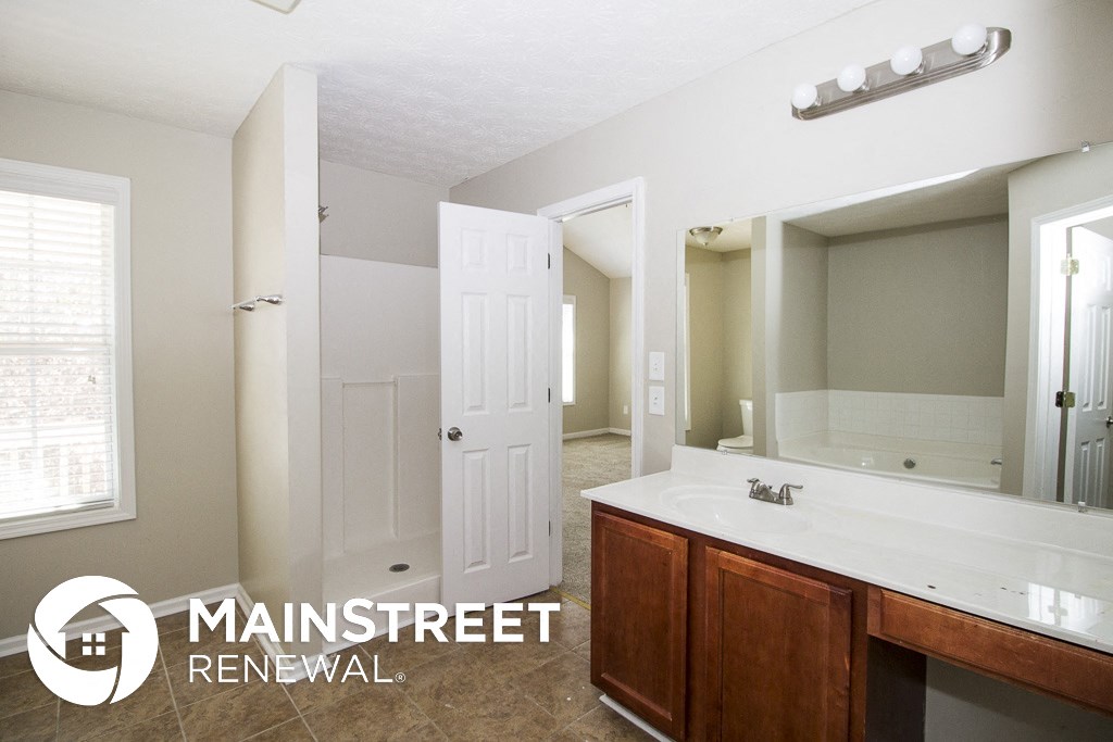 a bathroom with a large mirror and a sink and a shower