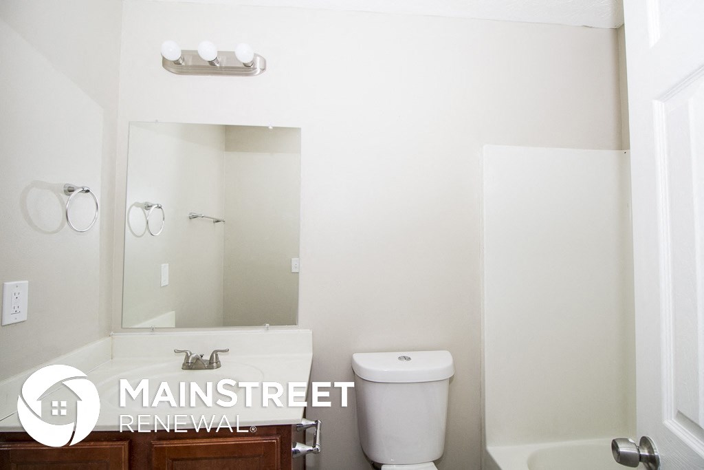 a small bathroom with a toilet and a large mirror