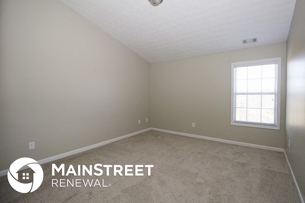 an empty room with carpet and a window