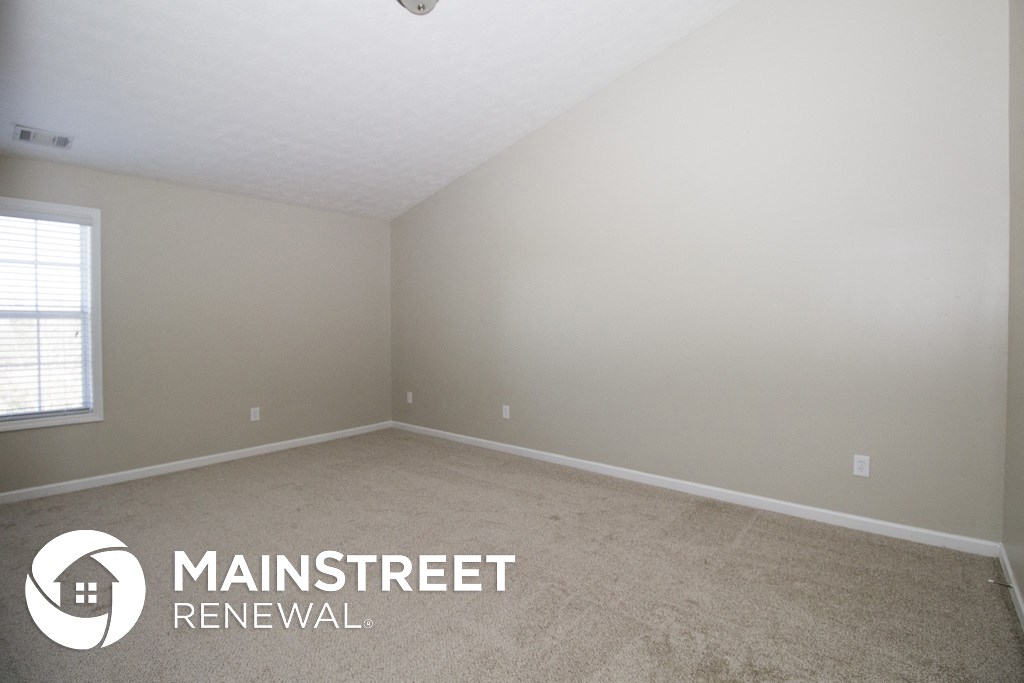 a bedroom with a carpeted floor and a window