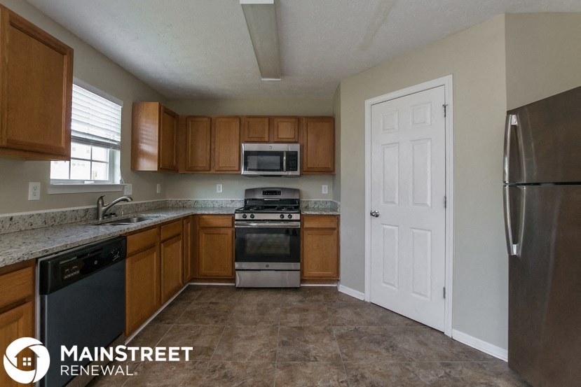 a kitchen with wooden cabinets and stainless steel appliances