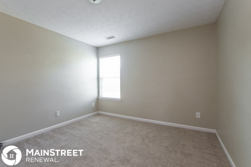 an empty room with a window and carpet