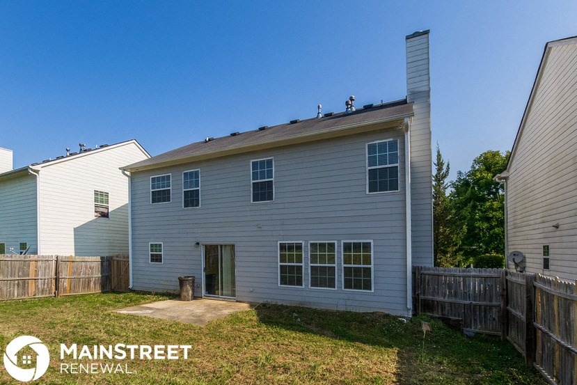a white house with a backyard and a fence