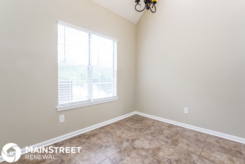 the living room of an empty home with a large window