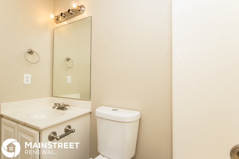 a bathroom with a white toilet and a sink and a mirror