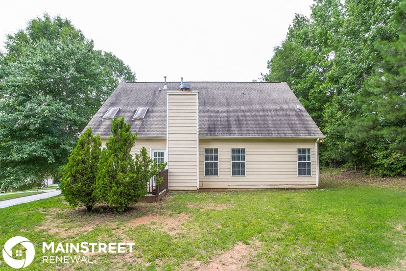 the front of a house with a yard and a tree