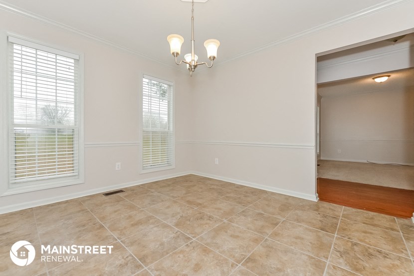 the living room and dining room of an empty house