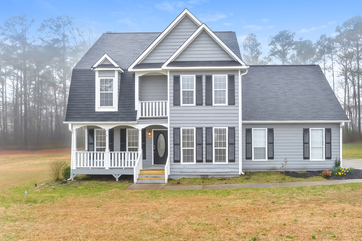 a with a black roof and a white front porch