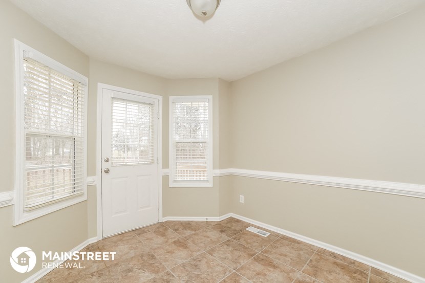 a living room with a white door and a tiled floor