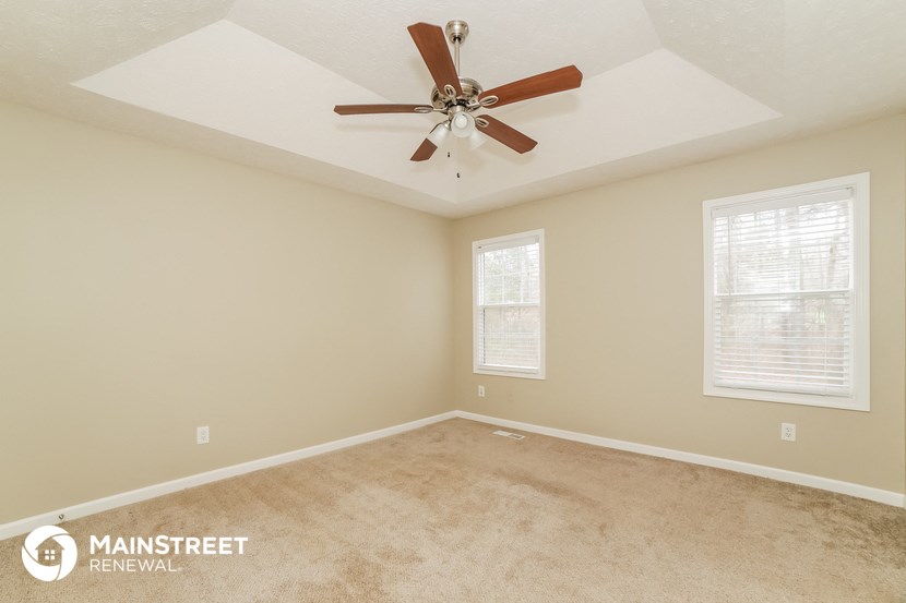 the living room of a home with a ceiling fan