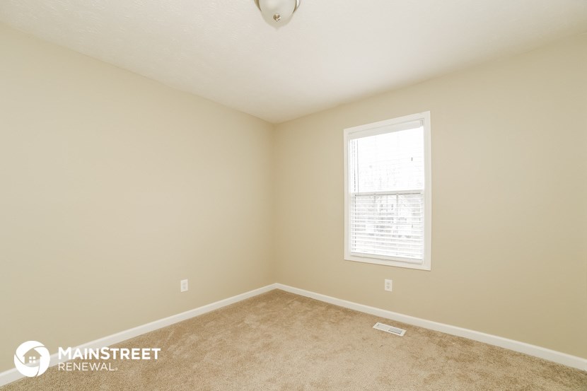 a bedroom with a carpeted floor and a window