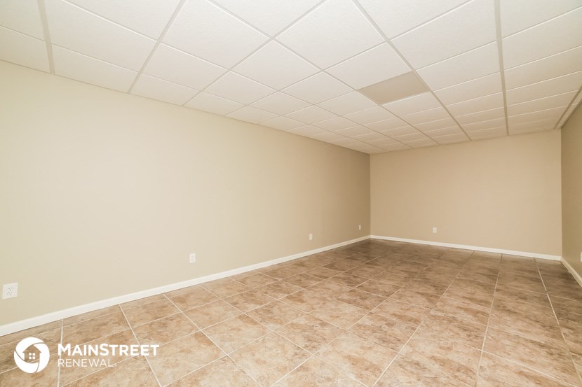 the spacious living room with tile flooring and beige walls
