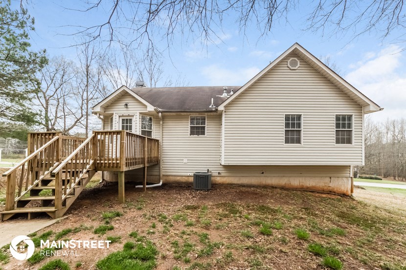 the back of the house with a deck and a porch