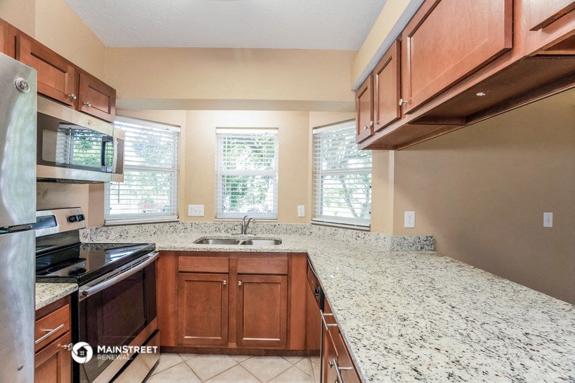 an empty kitchen with wooden cabinets and granite counter tops
