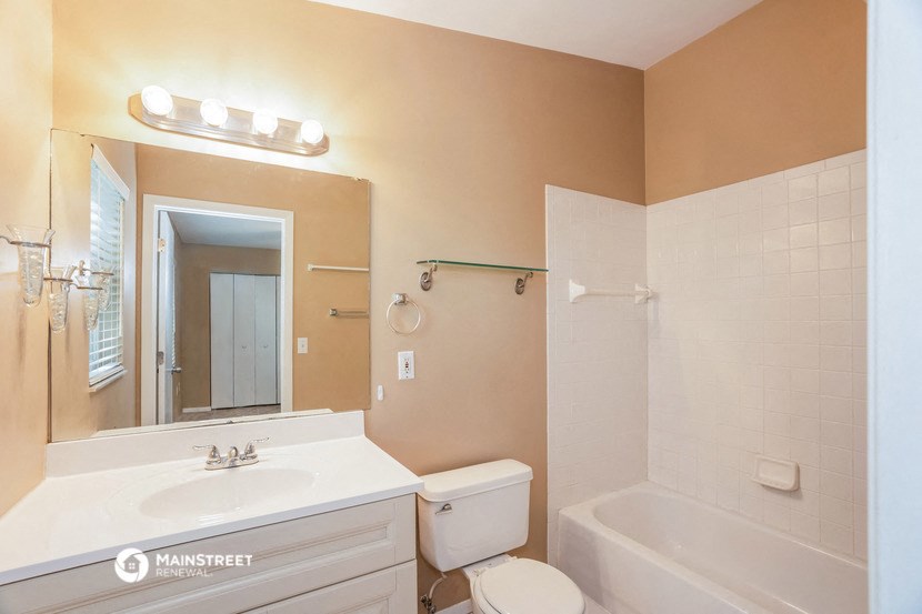 a bathroom with a sink toilet and a tub and a mirror
