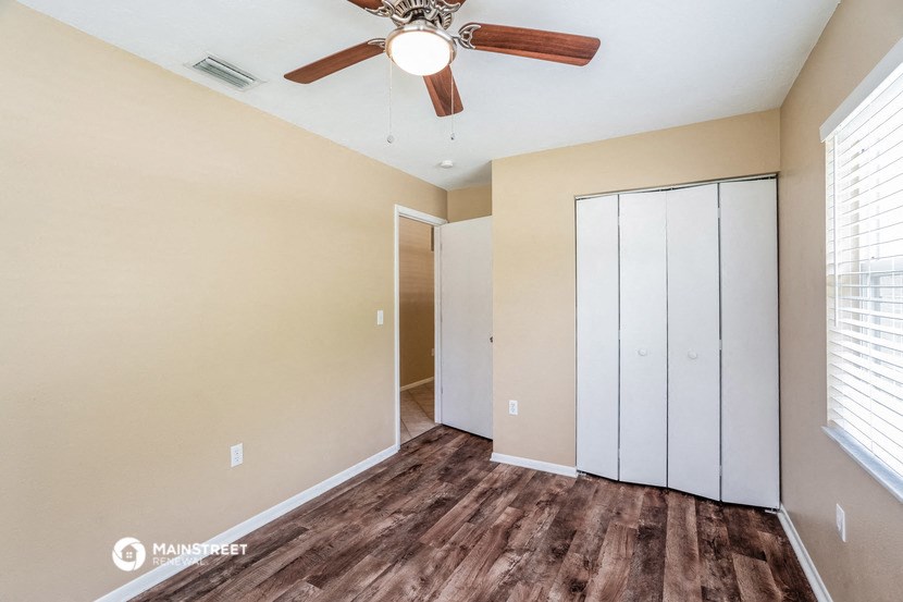 a bedroom with a ceiling fan and a closet
