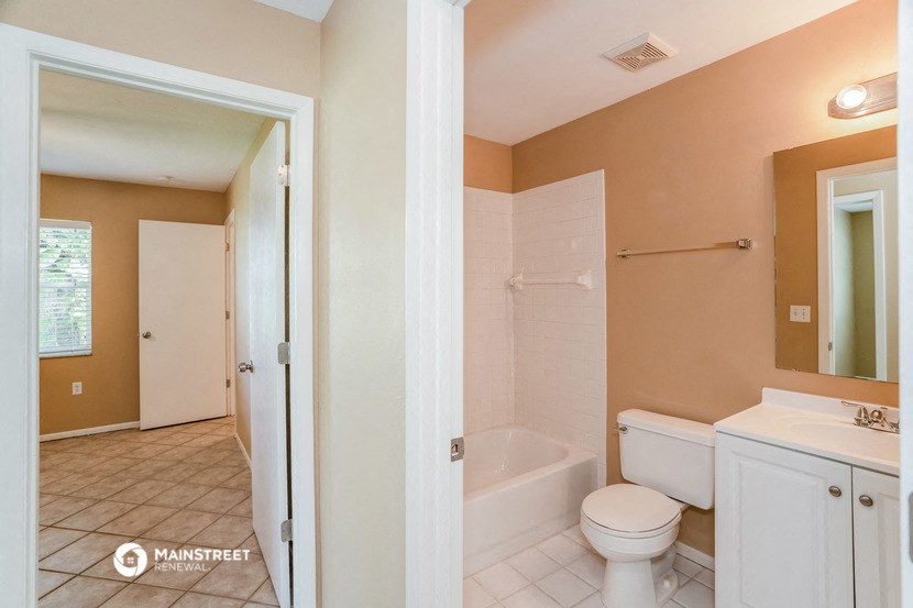 a bathroom with a toilet and a tub and a sink