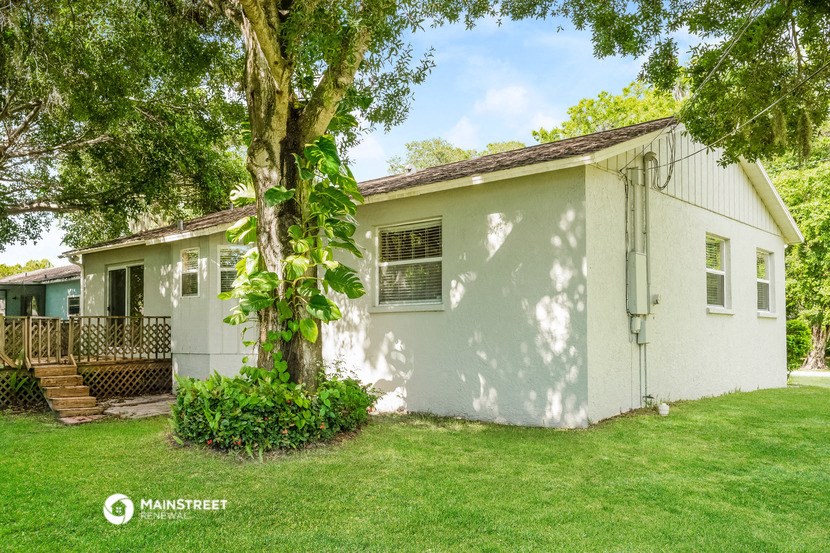 a small white house with a tree in the yard