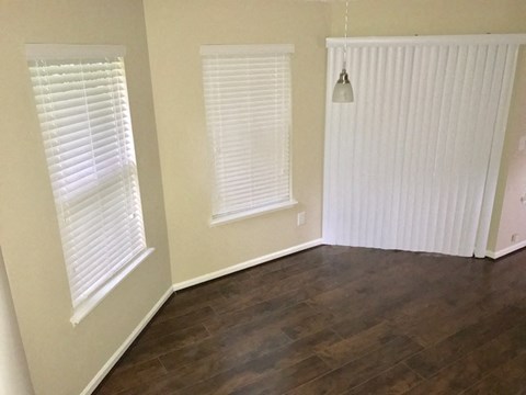 a living room with a hard wood floor and two windows
