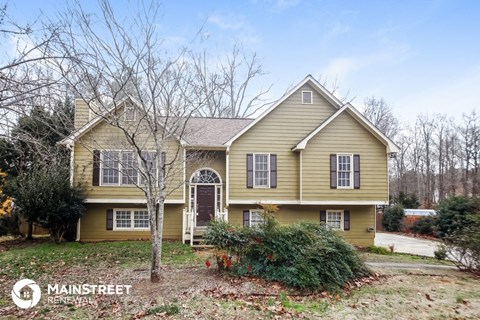 a yellow house with white windows and a yard