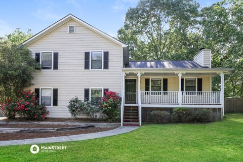 a white house with a front porch and a lawn
