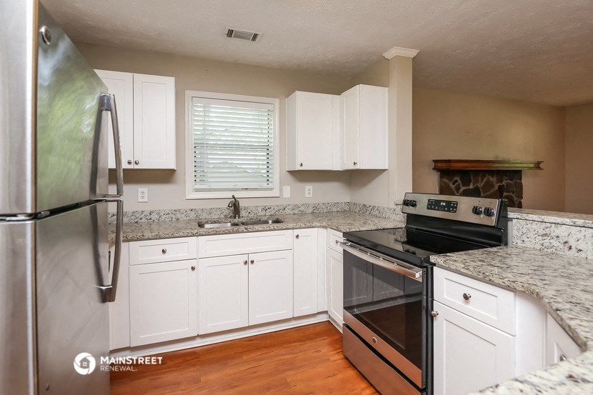 a kitchen with white cabinets and a stove and a refrigerator