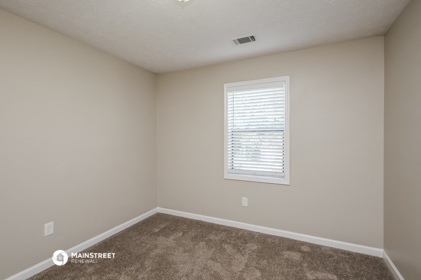 the upstairs bedroom has carpet and a window