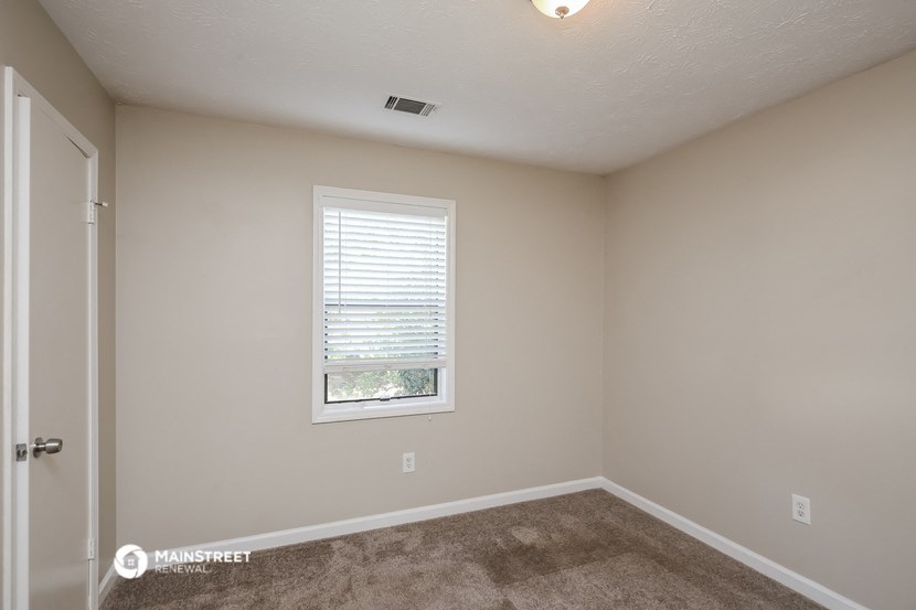 the interior of a bedroom with carpet and a window